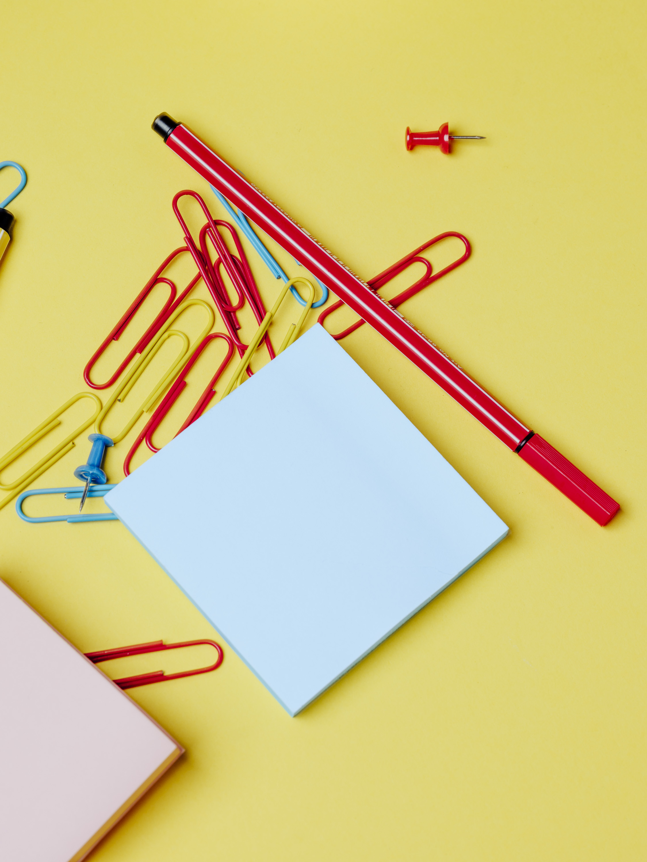 fond jaune, post it, feutre rouge, punaises, matériel scolaire